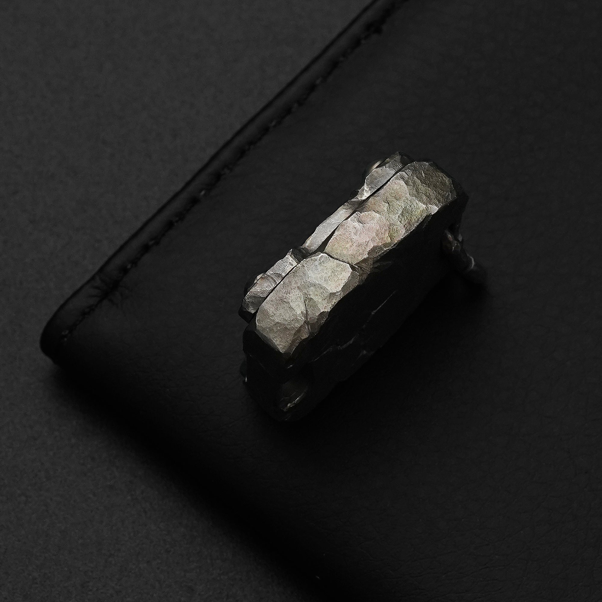 Edge detail of the MecArmy CMP2-HC hand-carved titanium EDC compass with irregular sculpted rock-like facets