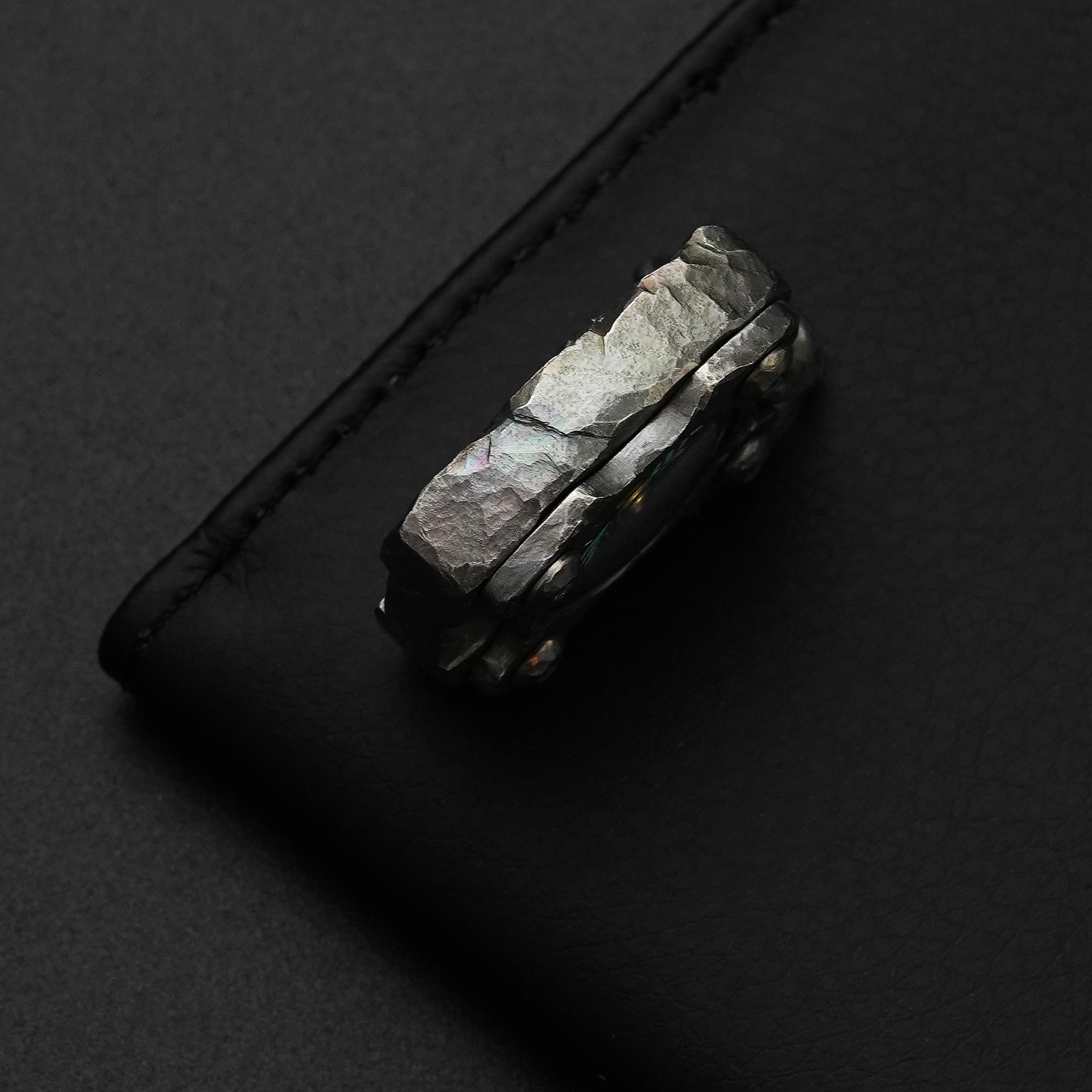Side detail of the MecArmy CMP2-HC hand-carved titanium EDC compass featuring unique hand-shaped facets and texture