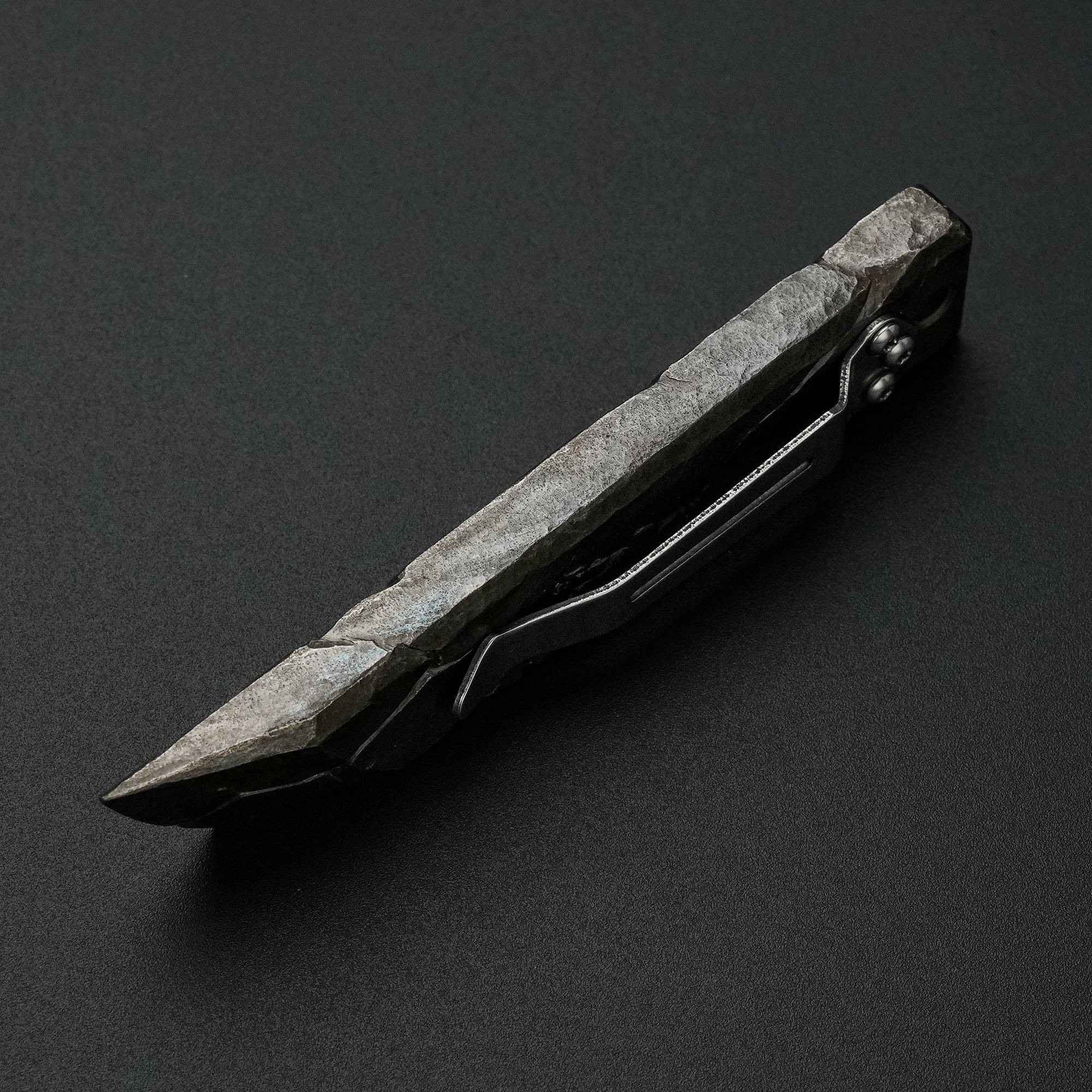 Side view of the MecArmy RL4-HC hand-carved titanium EDC pry bar showing sculpted edges and cracked titanium texture