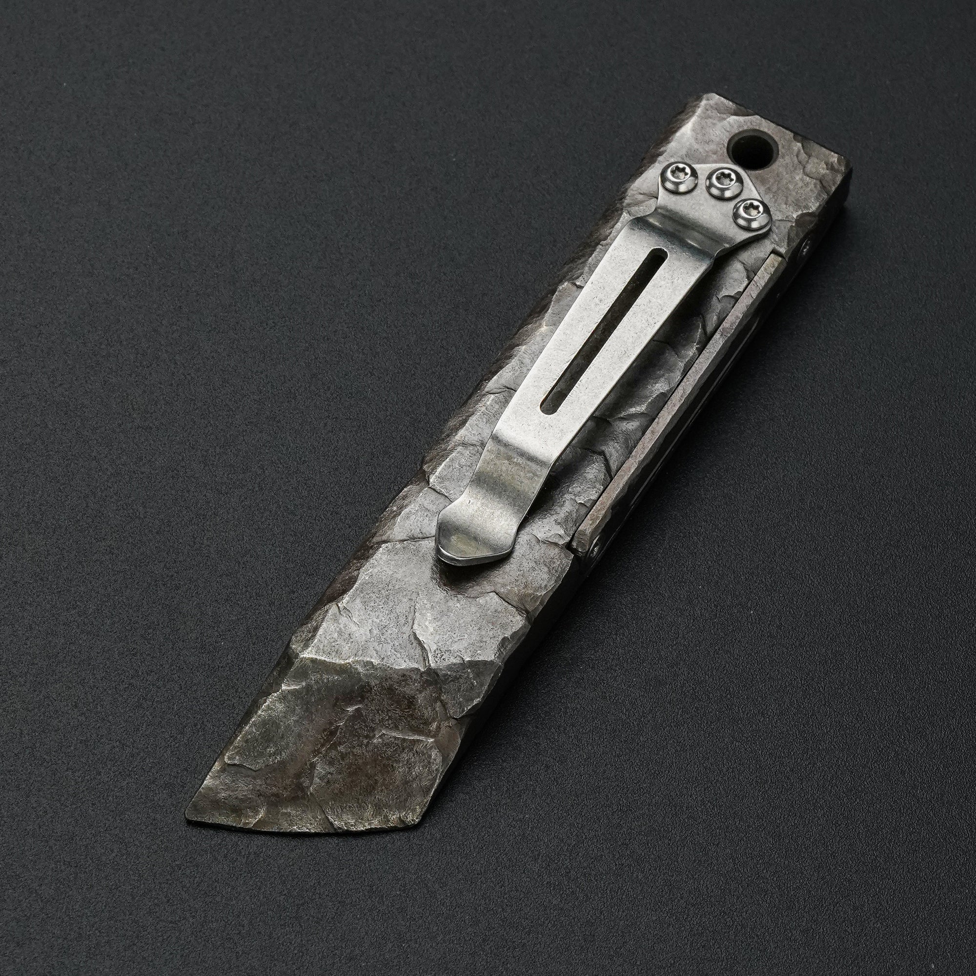 MecArmy RL4-HC hand-carved titanium EDC pry bar dinosaur skull edition showing the pocket clip and sculpted rock-like surface