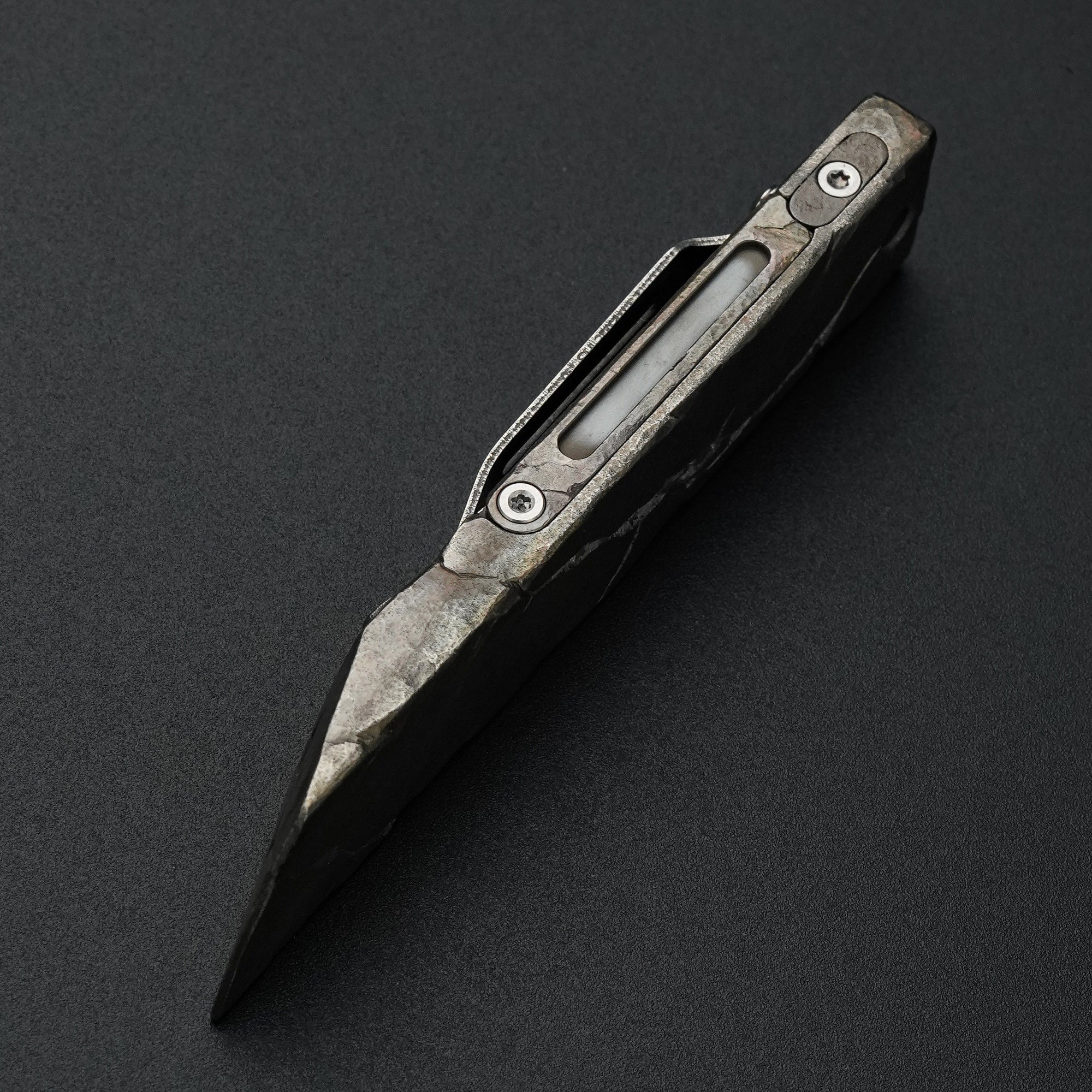 Side view of the MecArmy RL4-HC hand-carved titanium EDC pry bar with irregular sculpted edges and dinosaur skull detailing